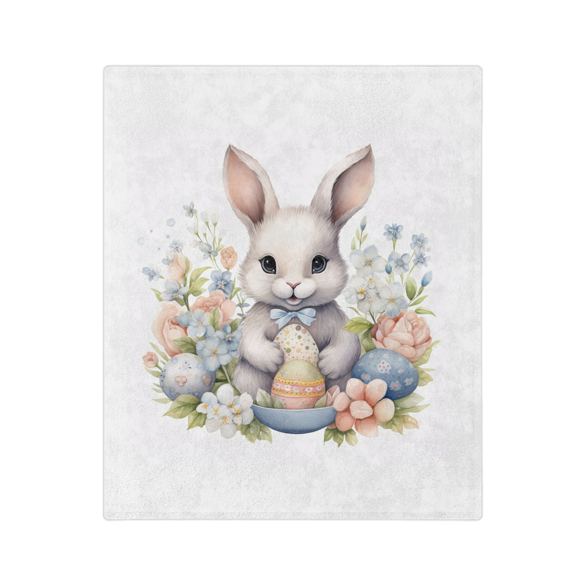 "Close-up of a lightweight velveteen blanket featuring an adorable white cartoon bunny with a light blue bow tie, holding two decorated Easter eggs in its paws. The bunny is surrounded by soft pastel flowers in pink and light blue, and more patterned Easter eggs are visible around it, one blue to the right and another blue one on the left. 