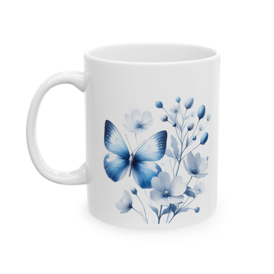 White ceramic mug with an elegant illustration of a large blue butterfly flying among various blue and white flowers and delicate leaves.

