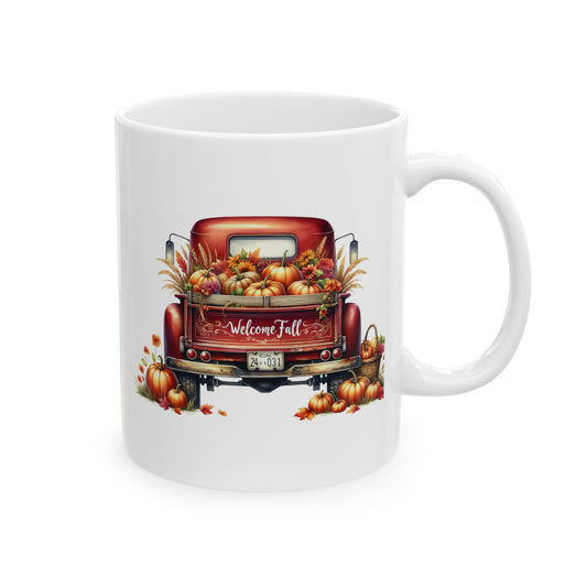 White ceramic coffee mug with a watercolor illustration of the back of a vintage red pickup truck filled with pumpkins, gourds, and fall foliage, with "Welcome Fall" written on the tailgate, and scattered leaves and pumpkins around.