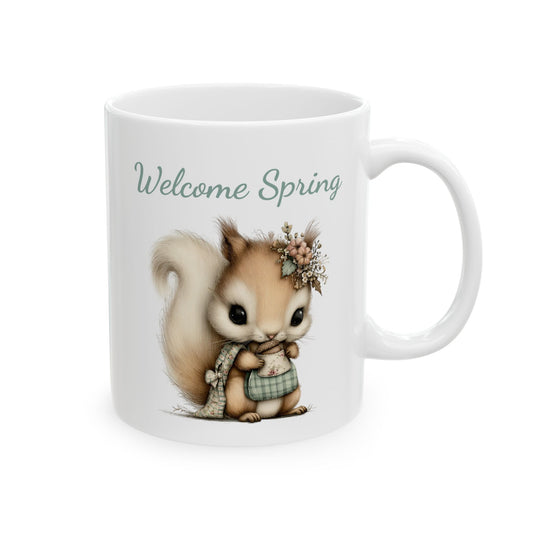 White ceramic coffee mug printed with sage green Welcome Spring text above an adorable woodland squirrel holding a small acorn