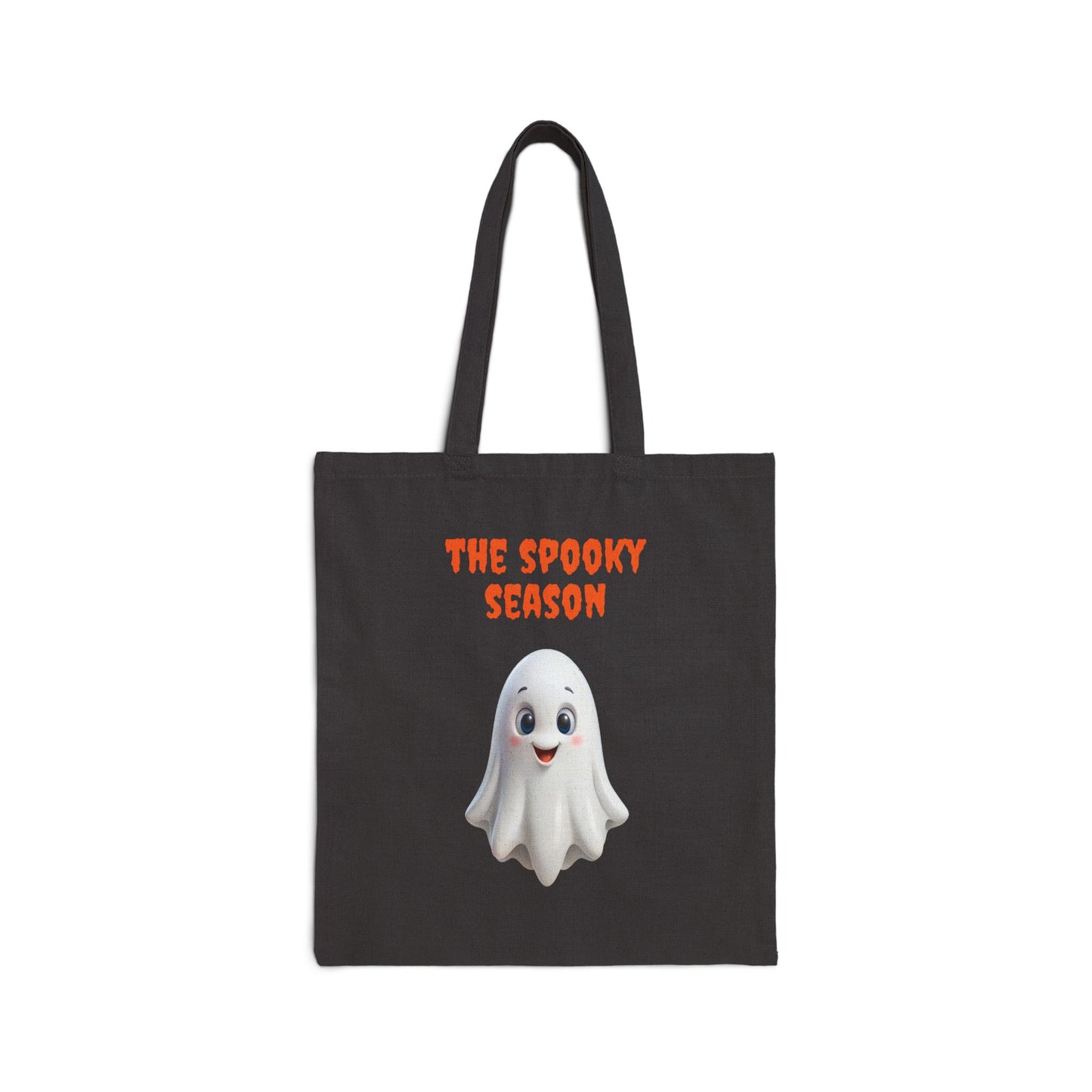 A black 100% cotton canvas tote bag featuring an illustration of a cute white ghost with large, round eyes. The text "THE SPOOKY SEASON" is printed in orange above the ghost.