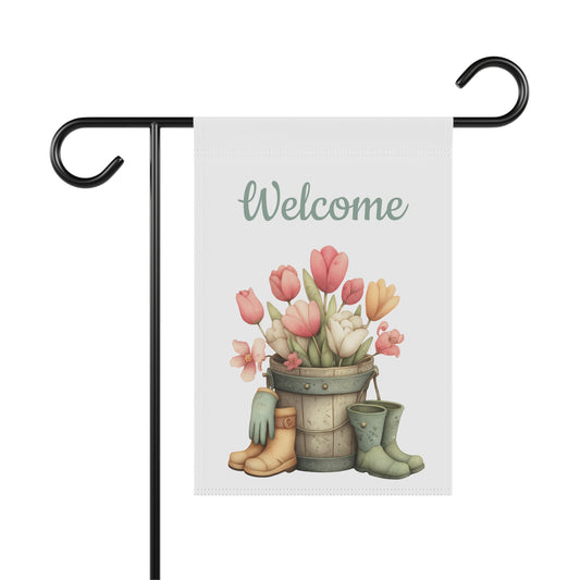 Pastel tulips in a wooden bucket with rain boots and gardening gloves below Welcome Spring text on a white garden flag, Outdoor spring garden flag on a metal stand featuring tulip bucket and rain boots artwork with Welcome Spring lettering, Floral tulip Welcome Spring yard flag for outdoor front porch and garden decor
