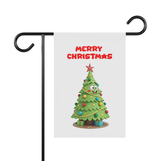 A white garden flag with a funny 3D-style illustration of a happy cartoon Christmas tree with googly eyes, decorated with colorful ornaments and presents, with "Merry Christmas" in red text above it. The flag is shown hanging from a black metal garden flag stand.


