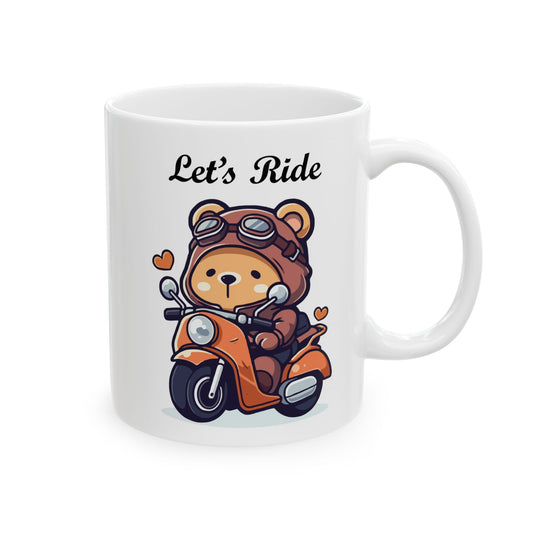 White ceramic coffee mug with a cute cartoon bear wearing a helmet and goggles, riding an orange scooter with small red hearts, and the text "Let's Ride" above it.