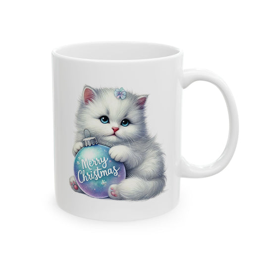 White ceramic coffee mug printed with a cute fluffy white kitten hugging a sparkling blue and purple ornament with Merry Christmas text