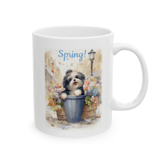 Front view of a white ceramic coffee mug featuring a cute, watercolor-style illustration of a black and white dog in a flower planter, with the text "Spring!".