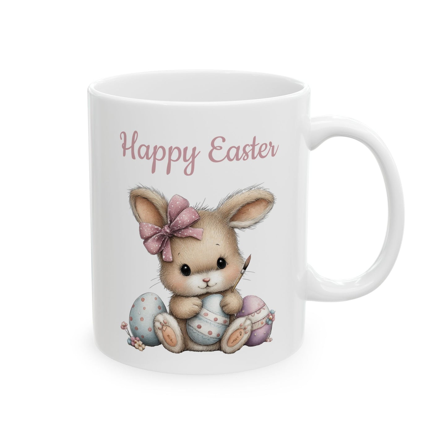 White ceramic mug with pink Happy Easter text and a cute bunny holding a paintbrush painting pastel Easter eggs