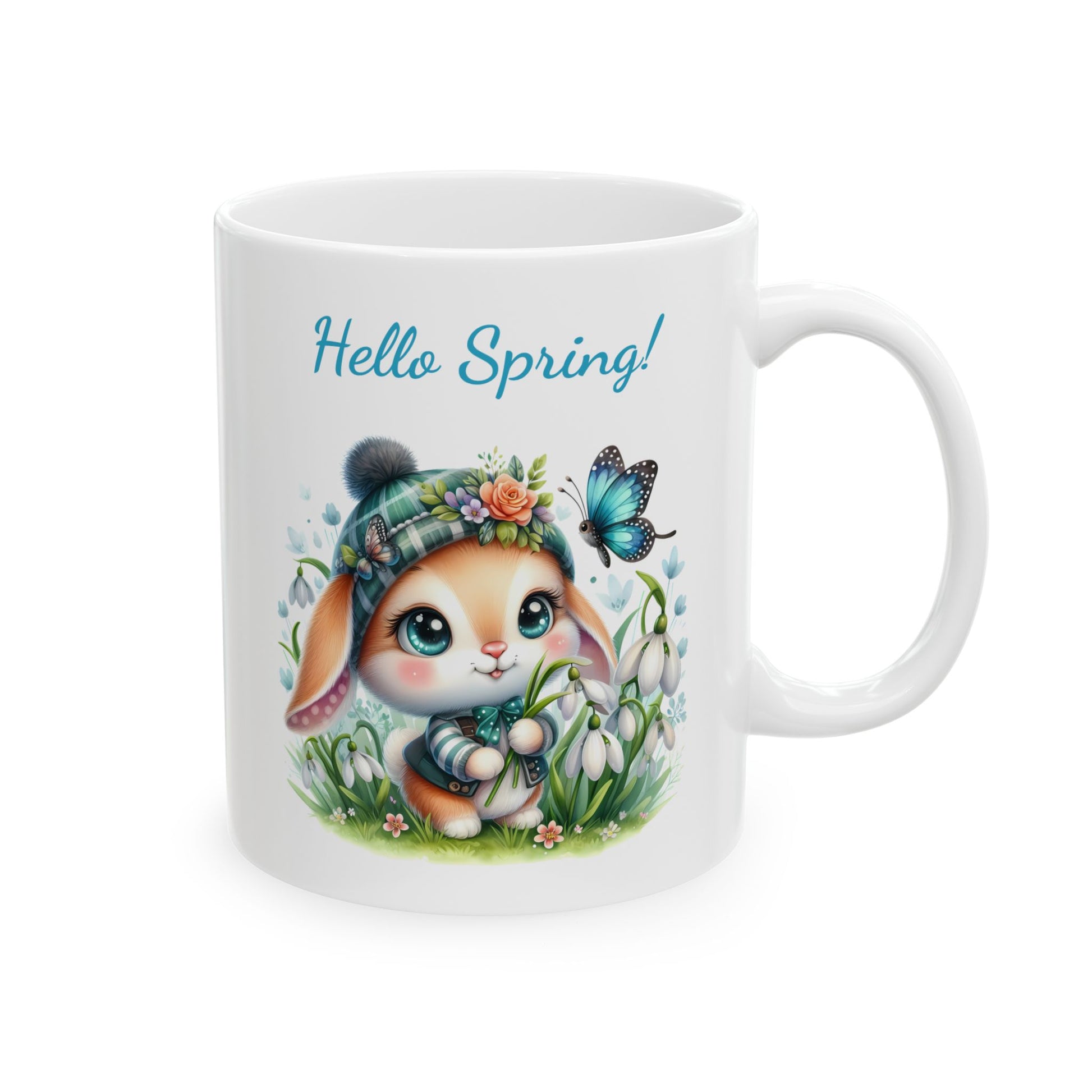 Front view of a white ceramic coffee mug with a cute, big-eyed cartoon bunny wearing a plaid beanie in a field of snowdrop flowers, with the text "Hello Spring!".