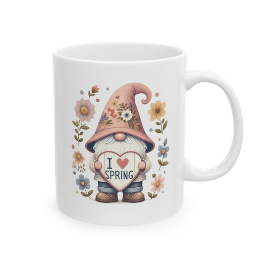 Front view of a white ceramic coffee mug with a cute, cartoon-style gnome holding a heart that says "I HEART SPRING" surrounded by pastel flowers.