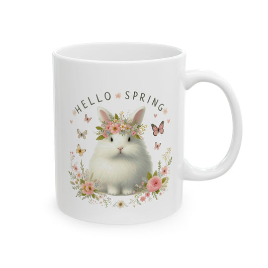 Front view of a white ceramic coffee mug featuring a cute, fluffy white rabbit wearing a floral crown and the text "HELLO SPRING."