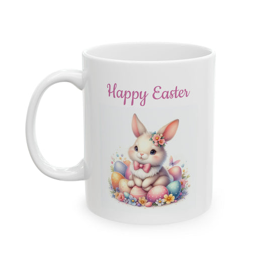 White ceramic mug with "Happy Easter" text in pink, featuring a cute light brown cartoon bunny with a pink bow and flower crown, sitting amongst a pile of colorful decorated Easter eggs and small flowers.

