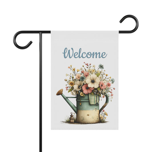 Spring garden flag featuring a vintage rustic watering can filled with soft pastel flowers under blue script text reading Welcome.