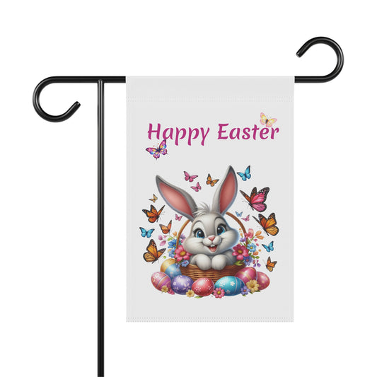White garden flag with "Happy Easter" in pink text, featuring a cute gray cartoon bunny sitting in a woven basket filled with flowers and colorful Easter eggs, surrounded by many vibrant butterflies. The flag is displayed on a black metal garden flag stand.

