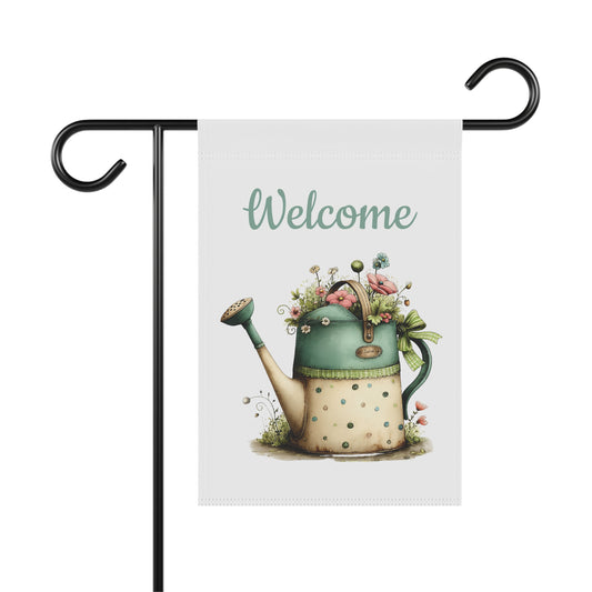 Garden flag on a black metal stand printed with teal script Welcome text above a vintage polka dot watering can overflowing with pastel flowers