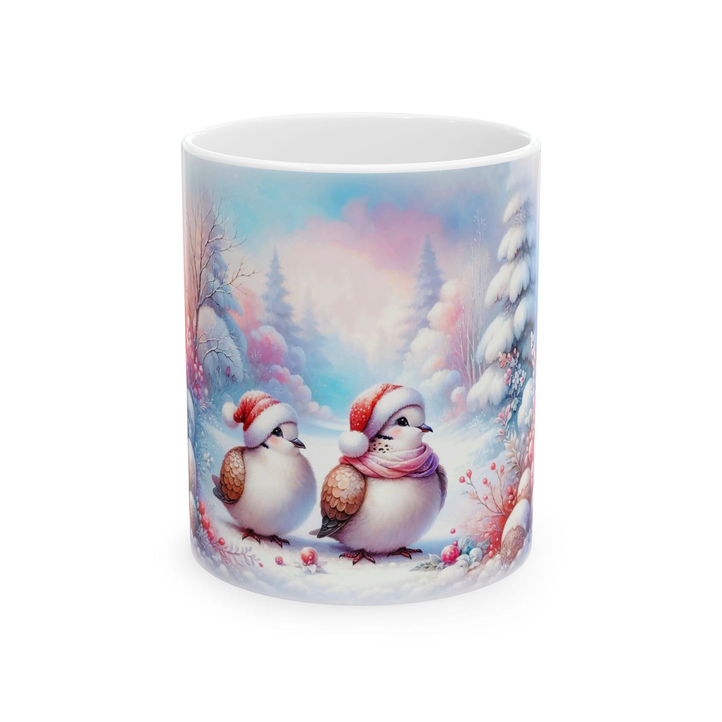 White ceramic coffee mug with a charming illustration of two small, fluffy birds in Santa hats, one wearing a pink scarf, standing in a snowy winter landscape with trees and pink and blue sky.

