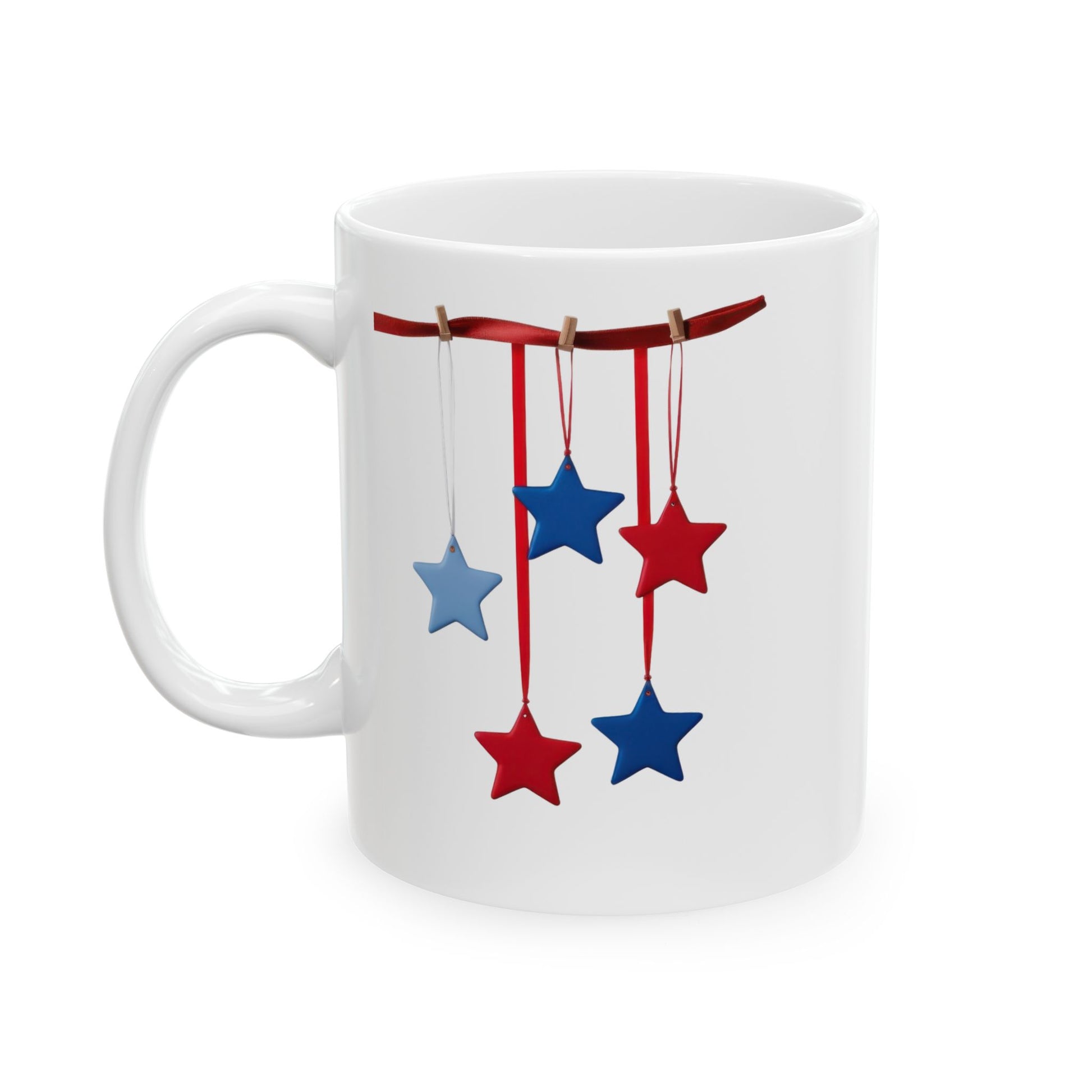 White ceramic coffee mug with a festive patriotic design showing red and blue stars hanging from a red ribbon with small clothespins