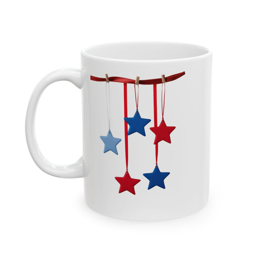 White ceramic coffee mug with a festive patriotic design showing red and blue stars hanging from a red ribbon with small clothespins