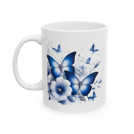 White ceramic mug with an elegant illustration of various blue butterflies flying around blue and white flowers and leaves.

