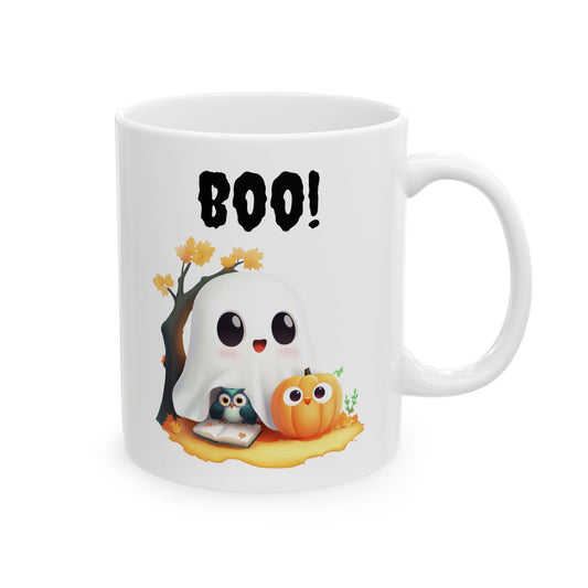 White ceramic coffee mug featuring an adorable cartoon ghost smiling next to a cute wide-eyed pumpkin and a small owl reading a book under a fall tree, beneath the black script text BOO!.